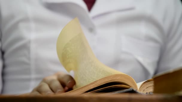 Closeup of a mans hand flipping through a paper book — Stock Video