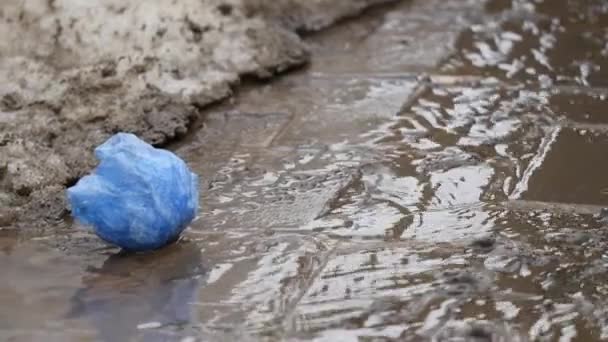 Вода течет из тающего снега, текущего вдоль асфальта. Таяние снега весной . — стоковое видео