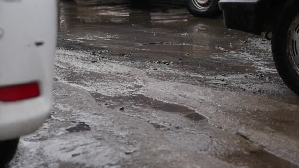 El agua fluye de la nieve derretida que fluye a lo largo del asfalto. Primavera derretimiento nieve . — Vídeo de stock