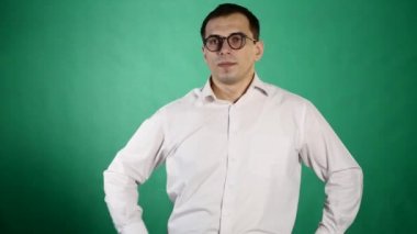 Baktılar hayrete erkek portresi yakından çenesi düştü kameraya benziyor, Gözlük, yeşil arka plan üzerinde izole dokunur