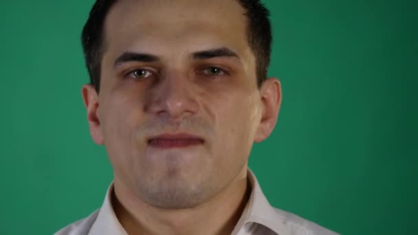Pohledný muž projevovat různé emoce. Zblízka. zelené pozadí — Stock video