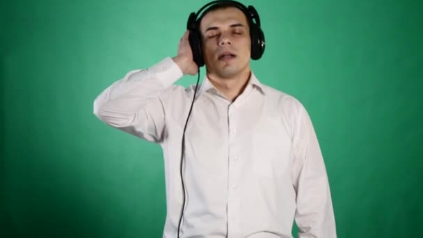 Young funny man with headphones on chroma — Stock Video