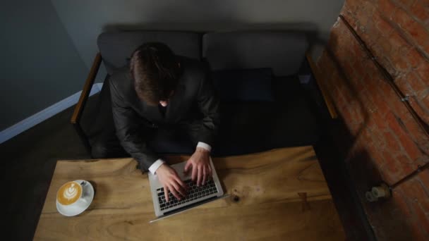 Uomo d'affari che usa il computer in un bar sul tavolo di legno. vista dall'alto — Video Stock