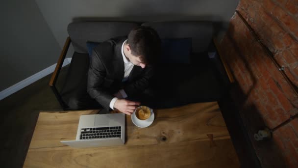 Zakenman die op laptop werkt en koffie drinken op café. bovenaanzicht — Stockvideo