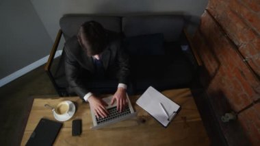 Kafede dizüstü bilgisayar üzerinde çalışan bir iş adamı. üzgün bir işadamıdır. üstten görünüm