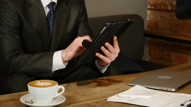 Femme d'affaires utilisant un ordinateur tablette dans un café sur une table en bois — Video