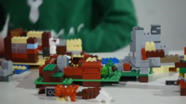 Childs'ın elleri bir küçük lego tuğla, Hands yakın Up oynamaya. LEGO inşaat oyuncak popüler bir çizgidir