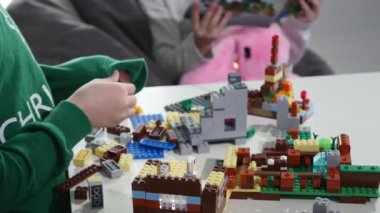 Childs'ın elleri bir küçük lego tuğla, Hands yakın Up oynamaya. LEGO inşaat oyuncak popüler bir çizgidir