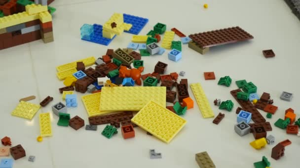 Un niño pequeño juega en el constructor. Juego de los niños diseñador. Cubos de colores. Los brazos pequeños son cubos conectados entre sí — Vídeo de stock