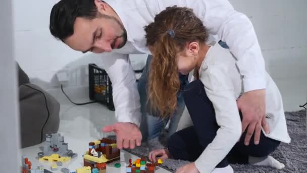 Vater mit Tochter spielt mit einem Bauarbeiter — Stockvideo