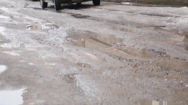 Ağır çekim, Close Up: Bulanık su su birikintisi içine araba sürücüleri olarak asfalt yol boyunca su sıçramalarına. Siyah sokak boyunca kahverengi sıvı spreyler