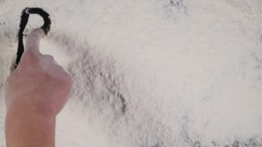 parmak kabartma bir beyaz un arka plan üzerine yazmak. üstten görünüm 4k