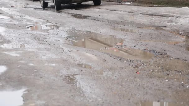 MOVIMIENTO Lento, CERRAR: Agua turbia salpica a través de la carretera de asfalto como coche conduce en charco. Brown spray líquido a través de la calle negra — Vídeos de Stock