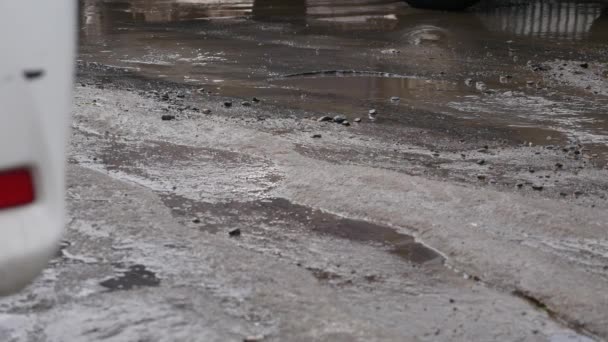 SLOW MOTION, CHIUSO: acqua torbida schizza attraverso la strada asfaltata come auto guida in pozzanghera. Spray liquidi marroni attraverso la strada nera — Video Stock