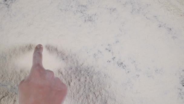 Finger write on a white flour background. top view 4k — Stock Video