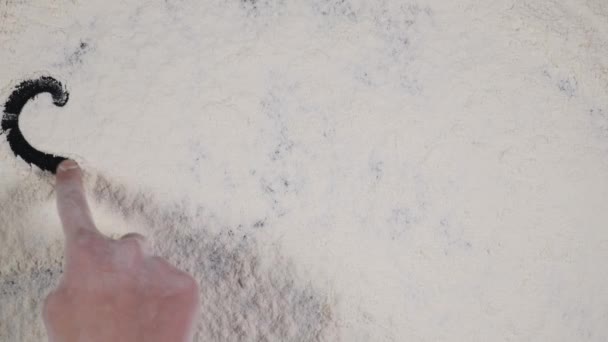 doigt écrire dimanche sur un fond de farine blanche. vue du dessus 4k 