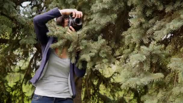 Jonge vrouw fotograaf werkproces schieten buiten in de natuur van het park — Stockvideo