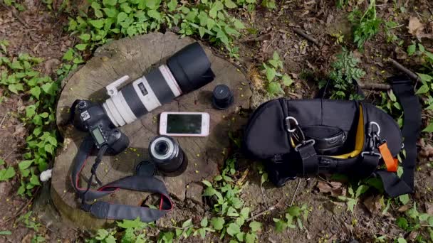 De camera en de telefoon ligt in het gras — Stockvideo