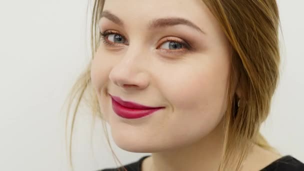 Closeup gezicht van een mooie jonge sexy voloptuous vrouw gewoon op zoek voor de camera. Aantrekkelijke prachtig meisje met heldere rode lippen en lang blond haar — Stockvideo