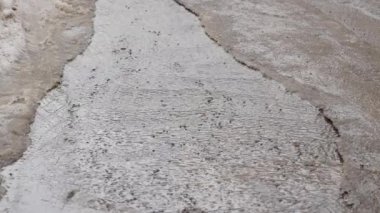 Asfalt akan eriyen kar üzerinden su akar. Kar eritme bahar.
