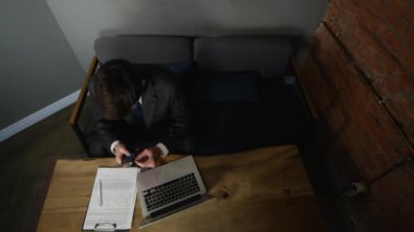 Ahşap masa üzerinde kafede telefon kullanarak iş adamı. üstten görünüm.