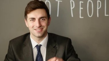 Takım elbiseli bir işadamı elinde gümüş bir bitcoin tutuyor.