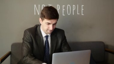 Dizüstü bilgisayarda çalışan işadamı ve kafede sevinir