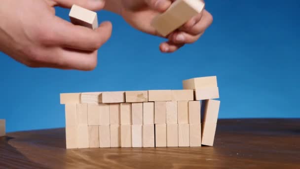 Man playing boardgame Jenga. blue background — Stock Video
