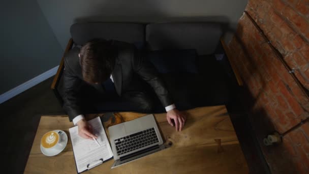 De zakenman ondertekent de documenten in het café. bovenaanzicht — Stockvideo