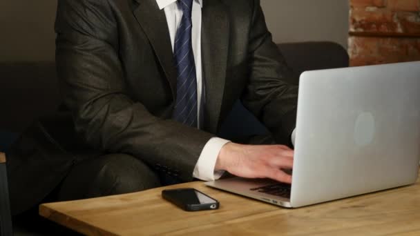Uomo d'affari che utilizza il computer portatile in caffè sul tavolo di legno — Video Stock