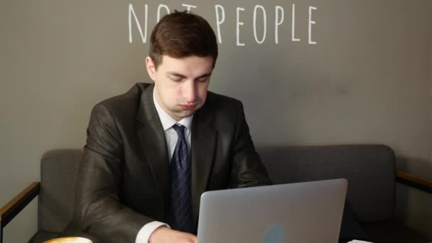 Empresario trabajando en el portátil en la cafetería. el hombre de negocios está molesto — Vídeo de stock