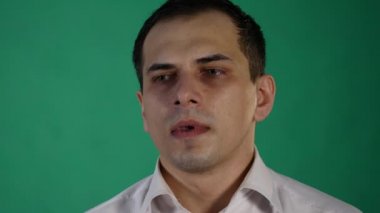 Üzgün adam iç geçiriyorum ve aşağı bakıyor. yeşil arka plan