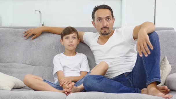 Padre attento a guardare la tv con suo figlio — Video Stock