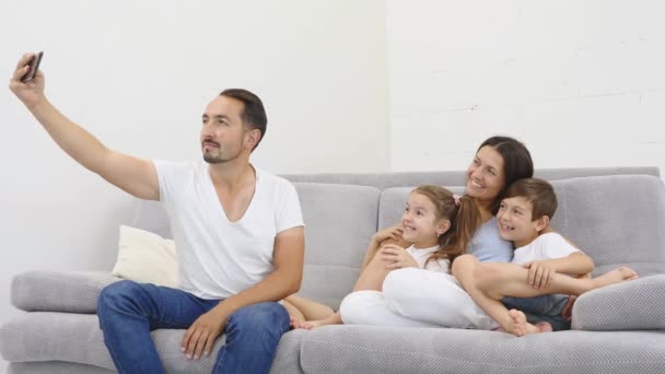 Glad familj med barn skrattar tar selfie tillsammans på telefon — Stockvideo