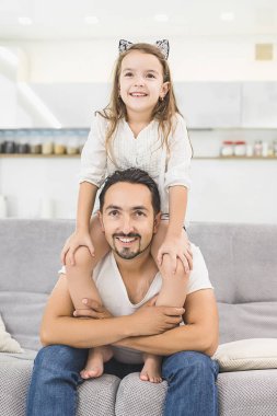 Yakışıklı baba ve sarılma, kameraya bakıyor ve gülümseyen sevimli kızı portresi