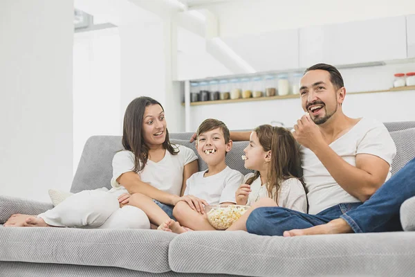 Szczęśliwy młody rodziny oglądanie filmów w domu z miskę z popcornem — Zdjęcie stockowe