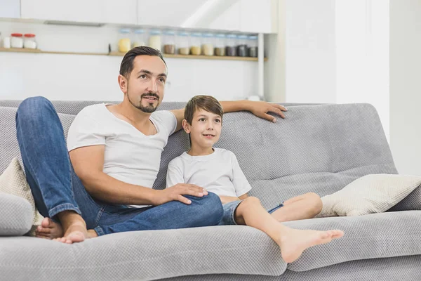 Atraente família jovem feliz, pai e filho assistindo TV — Fotografia de Stock