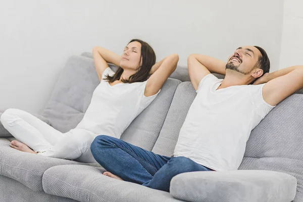Joyeux couple relaxant sur le canapé à la maison dans le salon. Vue latérale — Photo