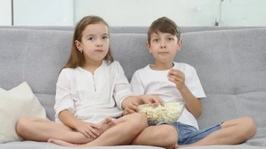 Evde Tv izlerken patlamış mısır yemek şirin çocuk. küçük bir kız kardeşi onu bir patlamış mısır vermez çünkü rahatsız