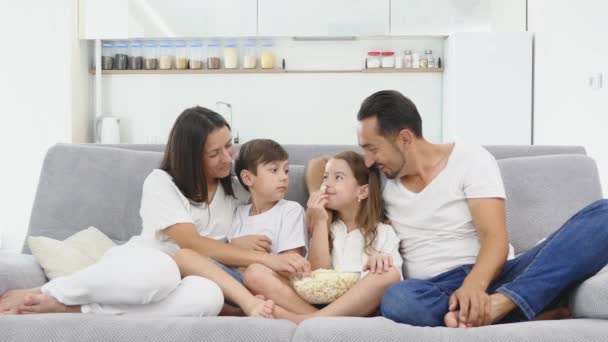 Família feliz jogar com pipocas no sofá — Vídeo de Stock