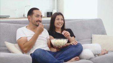 Aşık bir çift yeni evinde kanepede kucakladı televizyon seyretmek ve birlikte bir film izlemek. Kavramı: eğlence, sakin ol, tv.