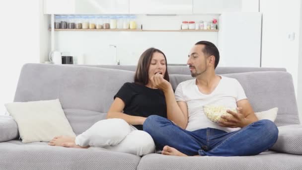 Personer, familj och fritid koncept - leende par med popcorn på tv hemma — Stockvideo