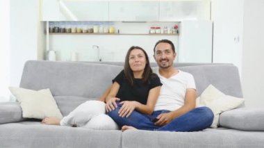 İki çocuklu ev, çocuklar ve ebeveynleri ile bir film izlerken kız rahatlatıcı mutlu aile