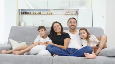 Kanepede oturan ve dans mutlu bir aile. Mutlu bir aile evde birlikte vakit. Annesi, babası, oğlu, kızı