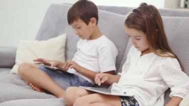 Mutlu ve tablet cihaz üzerinde oynayan kız. Oyun oynamayı ve çizgi film tablet bilgisayarda izlemek şirin çocuklar. Eğleniyor