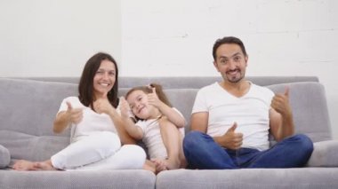Aile kanepede oturan ve başparmak gösterilmesini