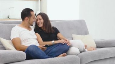 Genç çift birlikte evde kanepede oturup televizyon izlerken ve öpüşmek, romantik. Ev ve ilişkileri yaşam tarzı ve eğlence teknoloji