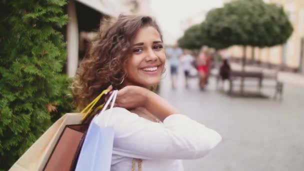 Uma mulher nas compras. Mulher feliz com sacos de compras desfrutando em compras. Consumismo, compras, conceito de estilo de vida — Vídeo de Stock