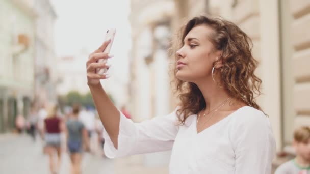 Frau macht mit dem Smartphone Fotos von der Altstadt. Nahaufnahme — Stockvideo