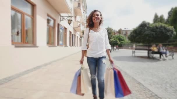 Mulher feliz com sacos de compras na cidade, câmera lenta — Vídeo de Stock